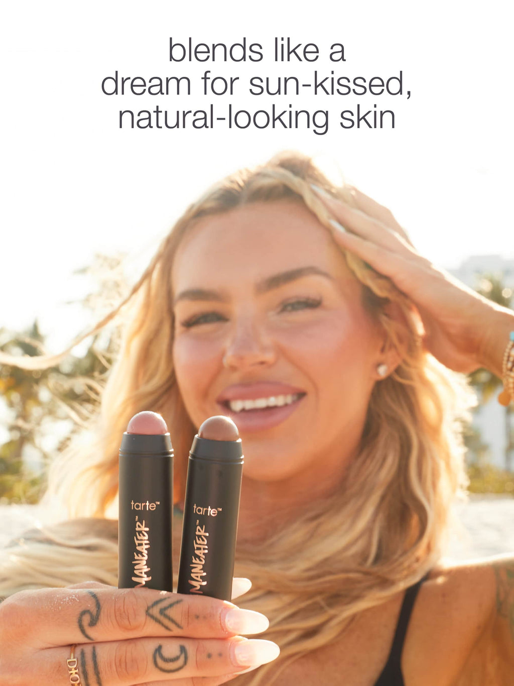 Woman holding tarte maneater™ cream bronze & blush stick duo with text about skin appearance