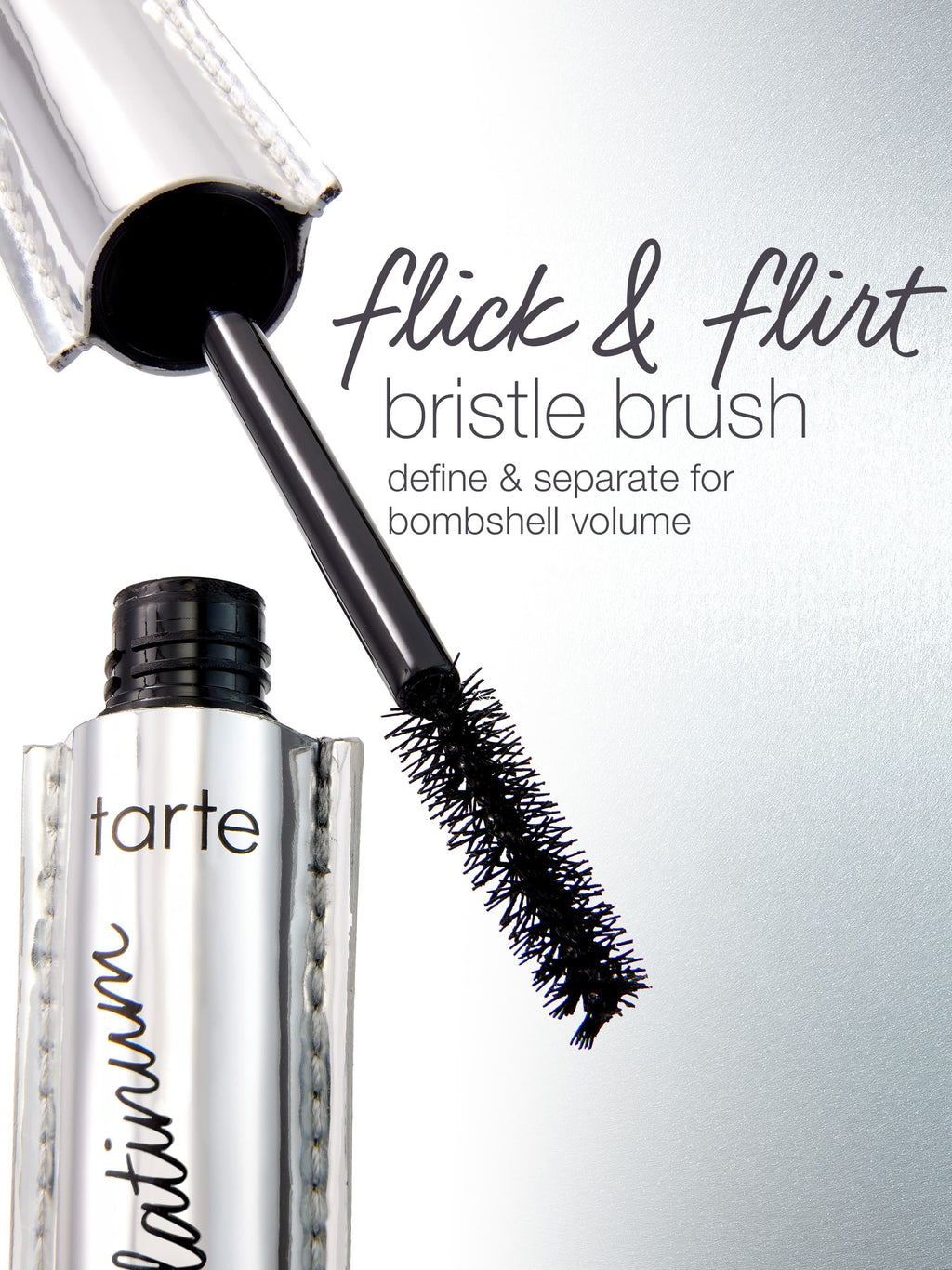 A mascara wand extends from a metallic tube labeled tarte platinum, with text beside it: flick & flirt bristle brush define & separate for bombshell volume. The background is light gray.