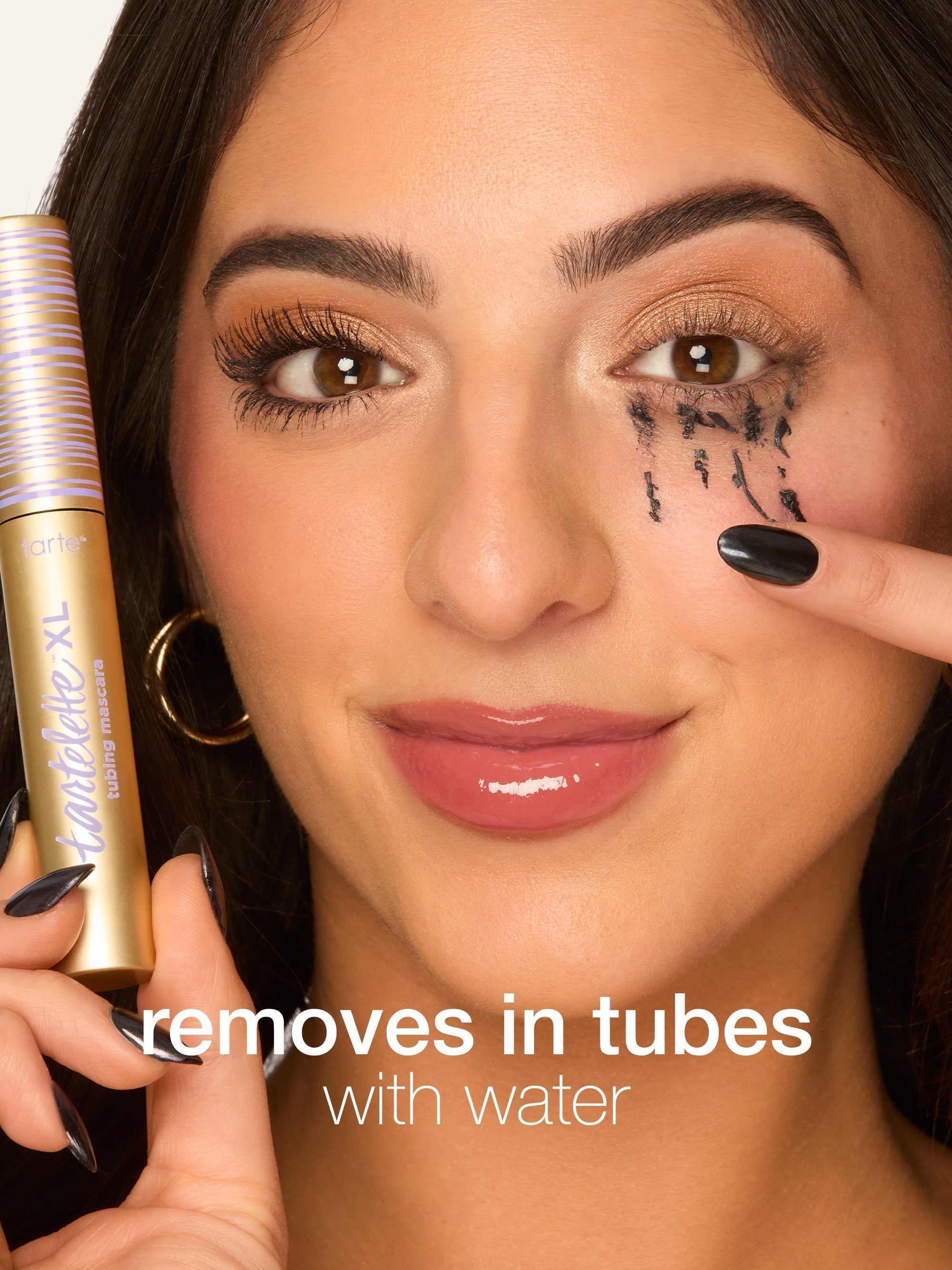 Woman holding a makeup removal product with text 'removes in tubes with water' on a white background
