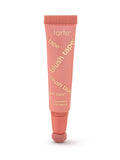 A coral-pink Tarte blush tube stands upright, applicator sponge at the base, on a white background. Text visible: tarte; blush tape™ (repeated diagonally); liquid blush; blush liquide.